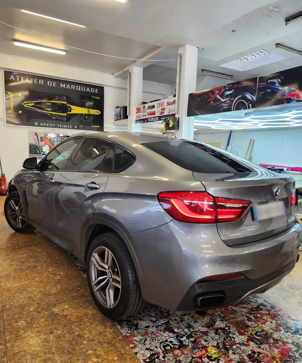 BMW X6 gris vu de trois quarts arrière avec ses vitrages teintés dans l’atelier Xpert Teinte à Toulon.