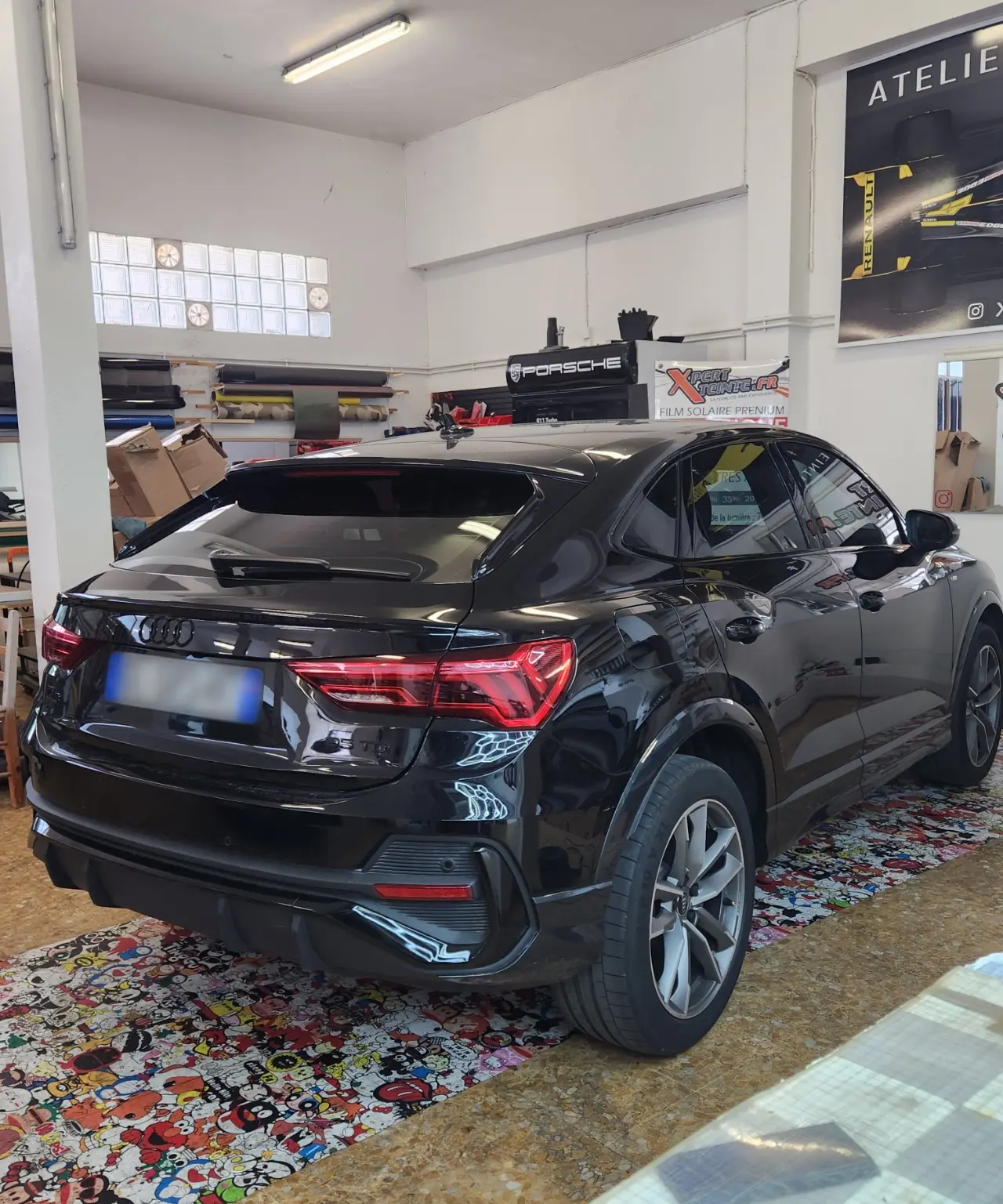 SUV Audi noir vu de trois quarts arrière, avec lunette et vitres latérales arrière teintées, dans l’atelier de Toulon.